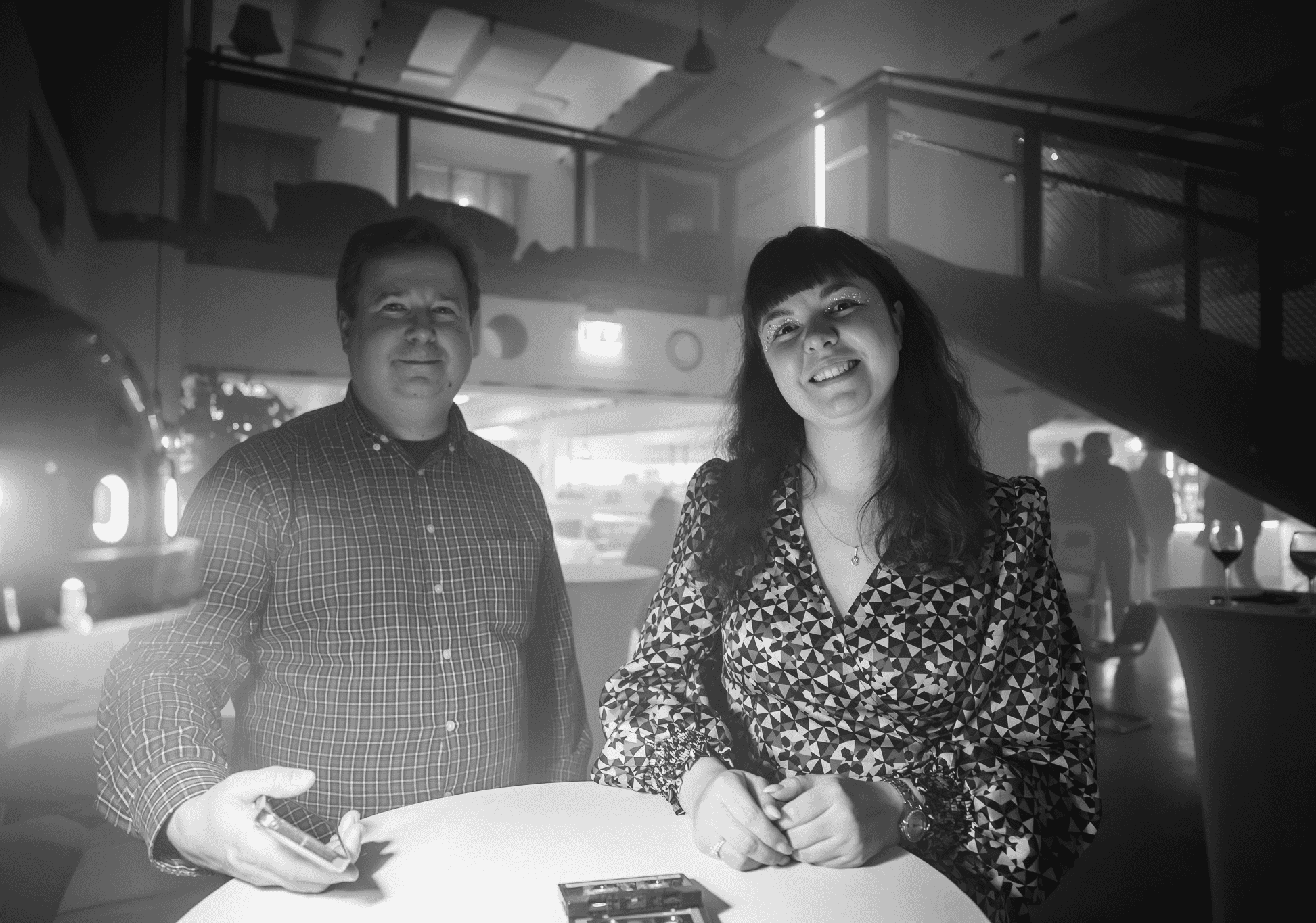 Two colleagues talking and smiling at a relaxed company event.